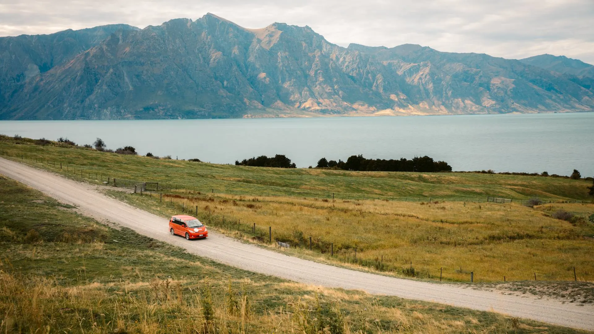 Orange Spaceships Campervan on a gravel road exploring the South Island of New Zealand