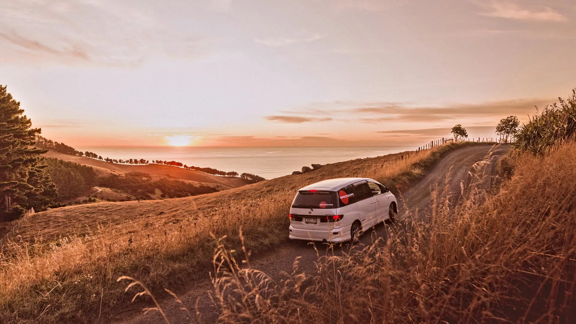 Spaceships campervan on a small hilly road near Raglan to see the sun set over the ocean
