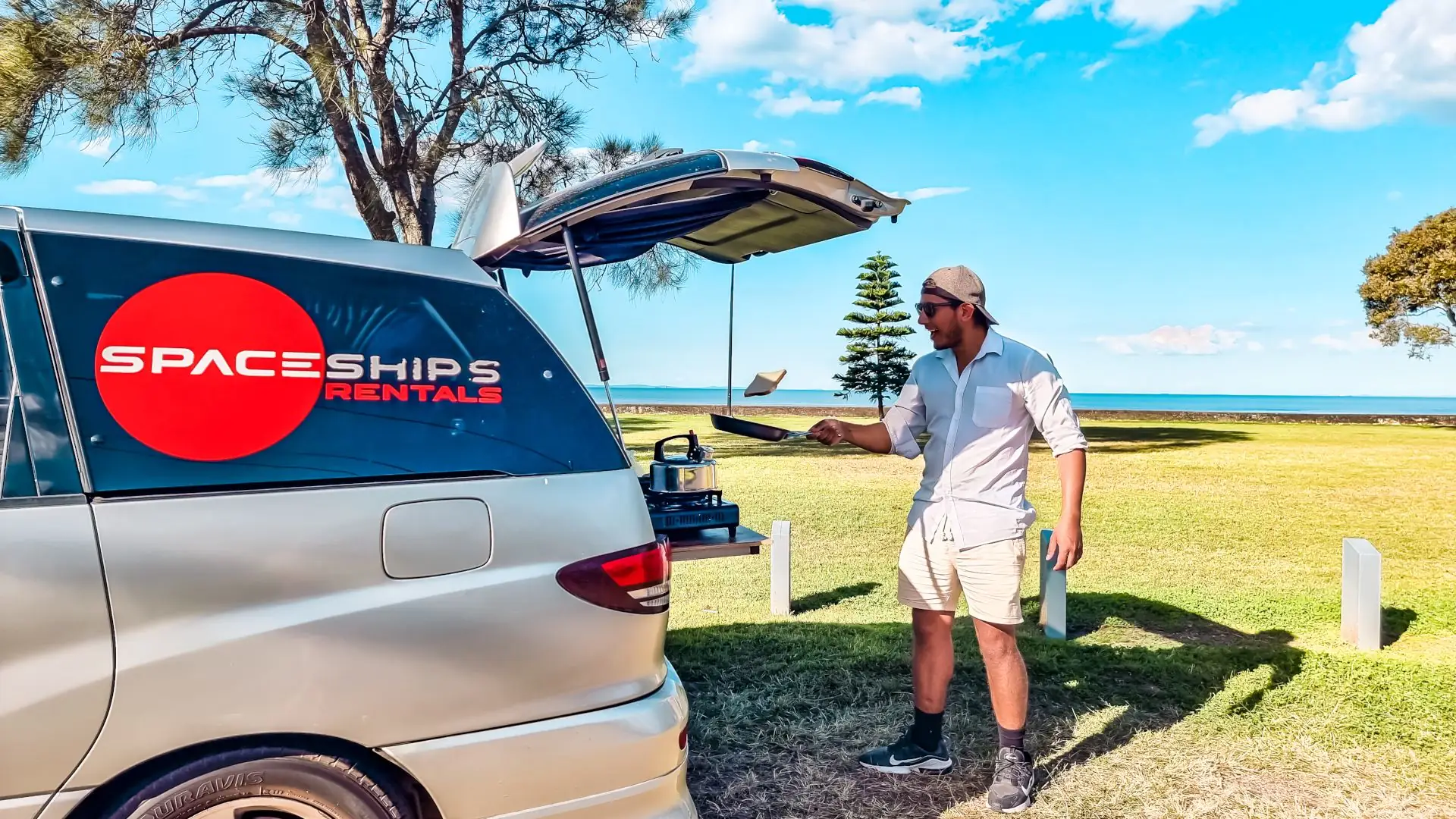 Space Traveller flipping toast while cooking at the back of the campervan